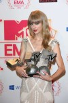 Taylor Swift poses backstage in the photo room with her awards for Best Female, Best Live and Best Look